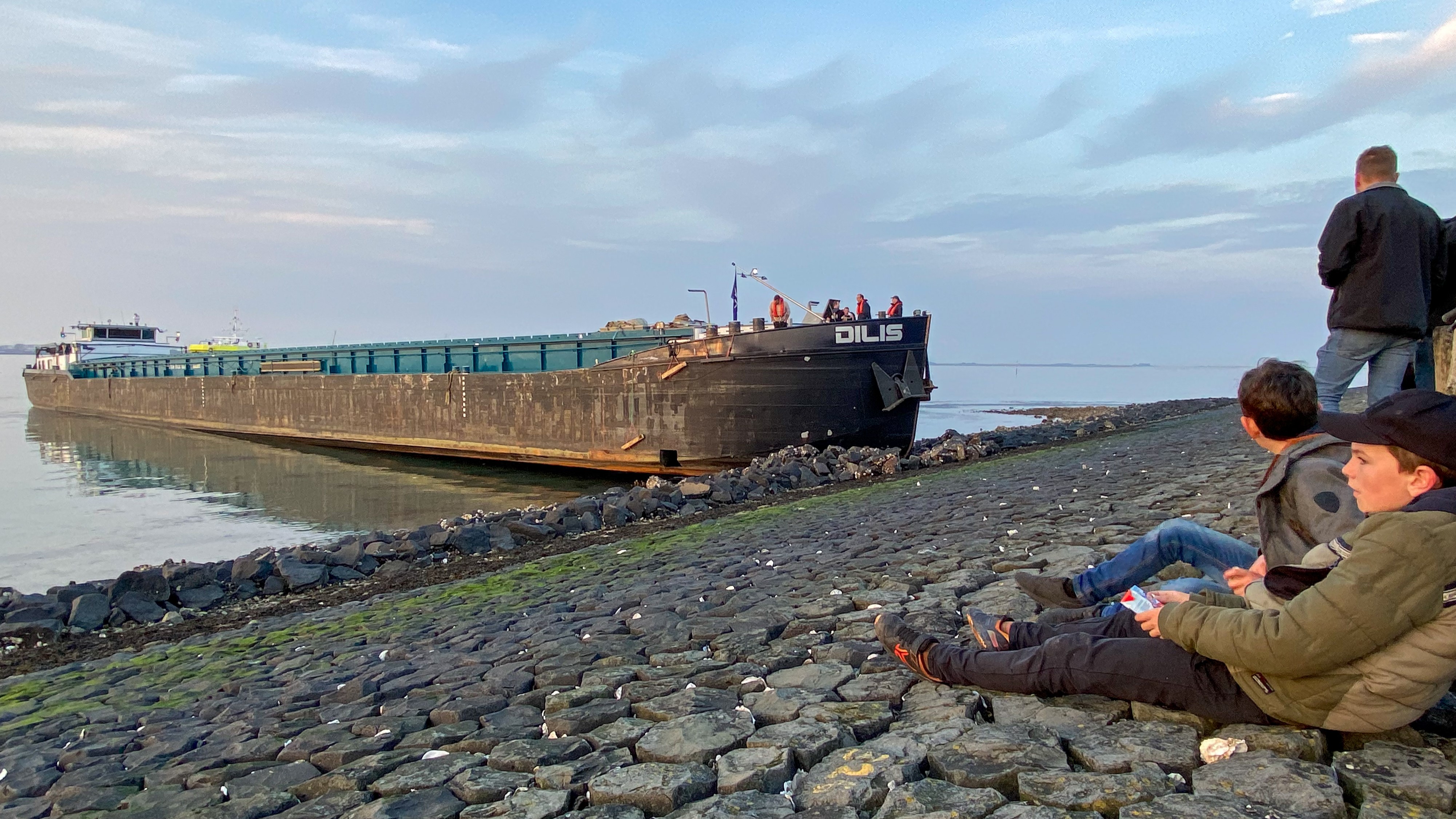 Binnenvaartschip vastgelopen tegen dijk bij Stavenisse