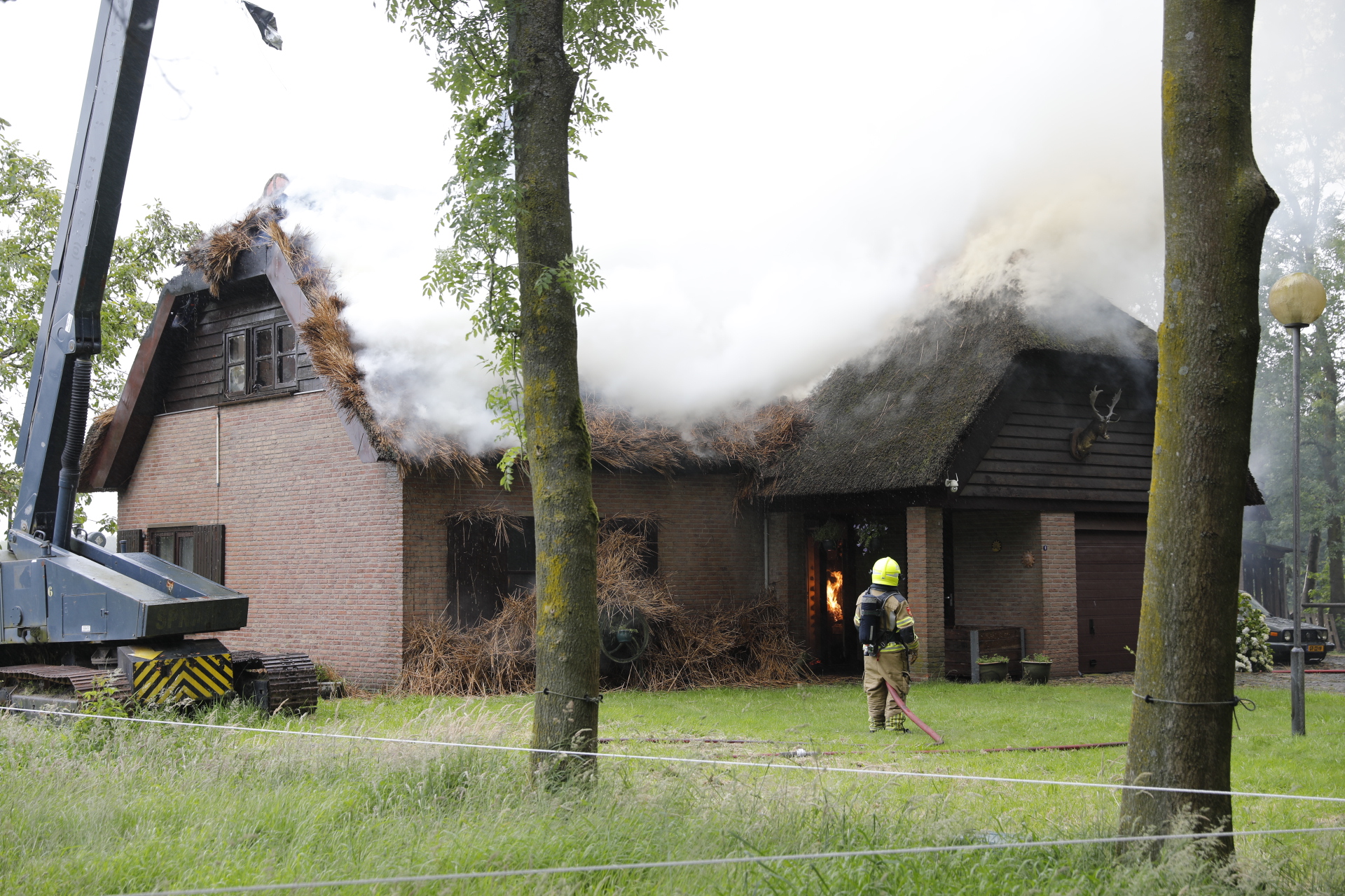 Brand ontstaan in rieten dak van woning in Huijbergen: huis volledig in brand