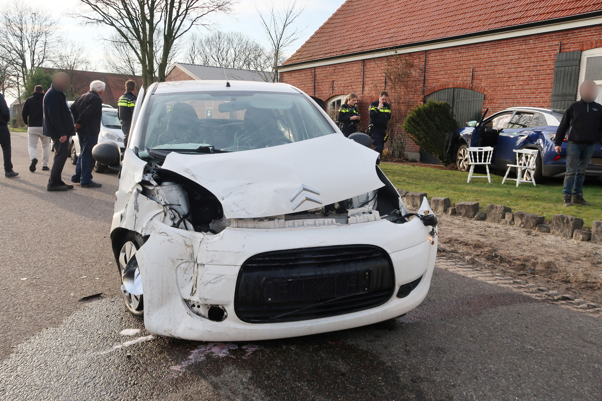 Schade aan twee auto’s door botsing, één voertuig eindigt tegen gevel