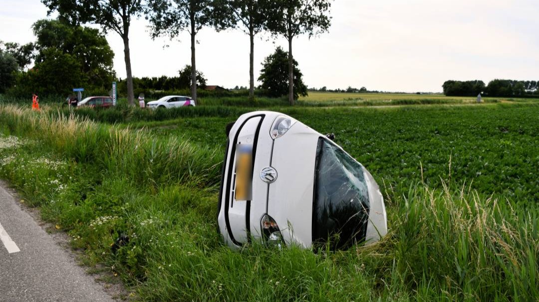Auto over de kop na botsing op Hogeweg bij Oud-Vossemeer