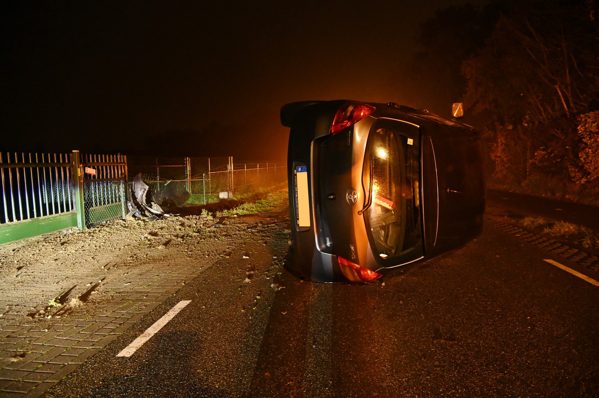 Auto belandt via slootje op zijn kant in Hoeven