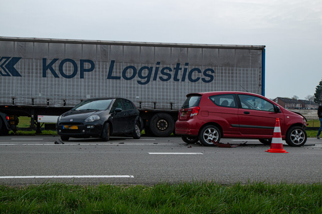 Auto’s botsen tegen elkaar, vrachtwagen wijkt uit en komt vast te zitten in berm