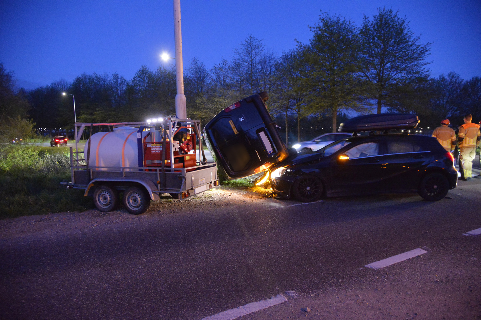 Auto en busje komen in botsing, busje komt op zijkant tegen paal terecht