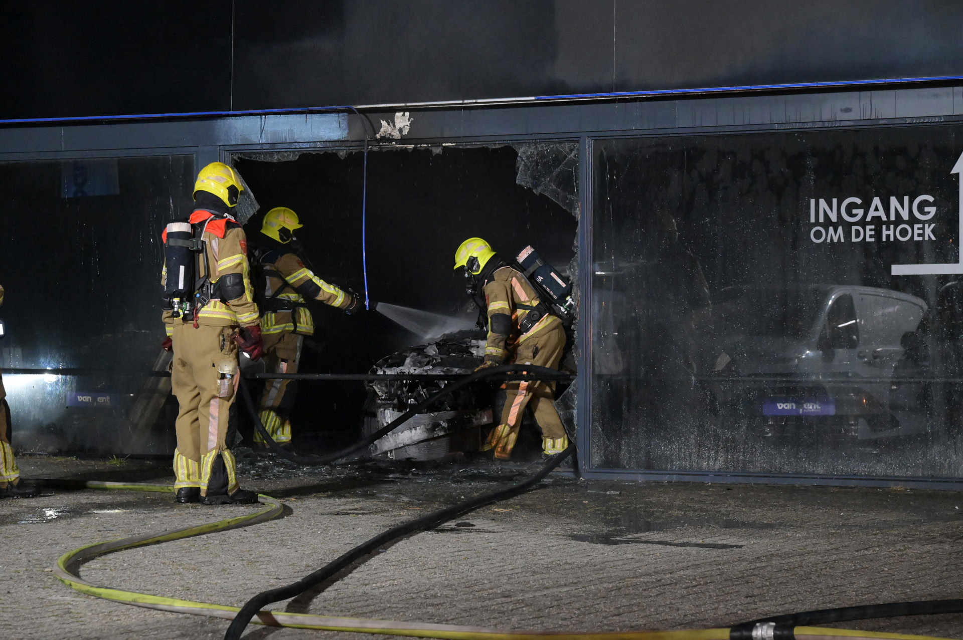 Auto in bedrijfspand vat vlam, brandweer schaalt groots op